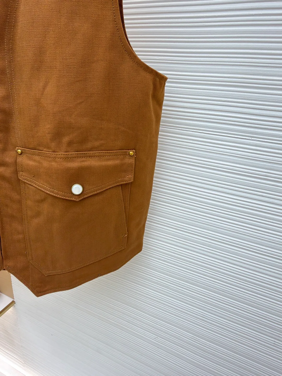 LOUIS VUITTON Nigo joint portrait work vest ●Original version: Purchased and developed for 16999 ●Item number: 1681331-B75 ●Fabric: denim fabric ●Technology: printing production ●Color: brown ●Version: fitted version ●Weight: about 785 grams ●Size: S-M-L-XL ●Description: Made of high-quality brown twill fabric, the texture is crisp and wear-resistant. The stability and texture of the fabric are ensured through fine weaving technology, which provides good support for the vest. The brand logo embroidery on the left uses a combination of bead embroidery and thread embroidery. The beads are arranged regularly, the embroidery stitches are fine, the pattern has a strong three-dimensional effect, and it is perfectly integrated with the fabric, highlighting the brand's luxurious craftsmanship. It adopts three-dimensional tailoring to fit the human body shape, making it comfortable to wear and fashionable. Double-thread reinforcement technology is used during sewing, the seams are smooth and compliant, the stitch spacing is even, and the lines are straight, reflecting the exquisite level of garment making. The buttons on the pockets are custom-made metal buttons with a smooth surface and brand details, high-quality texture and strong durability; the zipper is also customized by the brand, with the zipper puller bearing the brand logo, and the zipper is smooth and easy to pull. The quilted lining on the inside not only increases the warmth of the vest, but also improves the overall sophistication. The quilting lines are regular and reflect the meticulous craftsmanship. The design of the large pockets is both practical and decorative, with neat stitching on the edges of the pockets; the lines of the neckline and body are simple and elegant, and the overall craftsmanship details reflect the brand's high-end production standards. The overall wiring is straight and delicate, the fabric is comfortable and soft, and the color is consistent without color difference. It can be matched with the same style to create a fashionable look and control various occasions. Customized accessories, complete with three standards, same style for men and women!